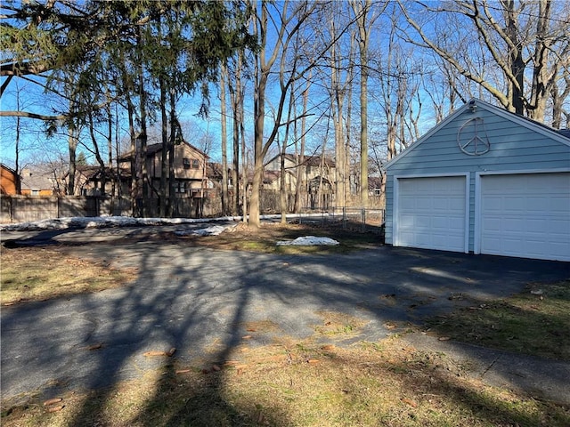 exterior space featuring an outdoor structure, fence, and a detached garage