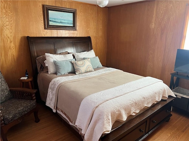 bedroom with wooden walls and wood finished floors