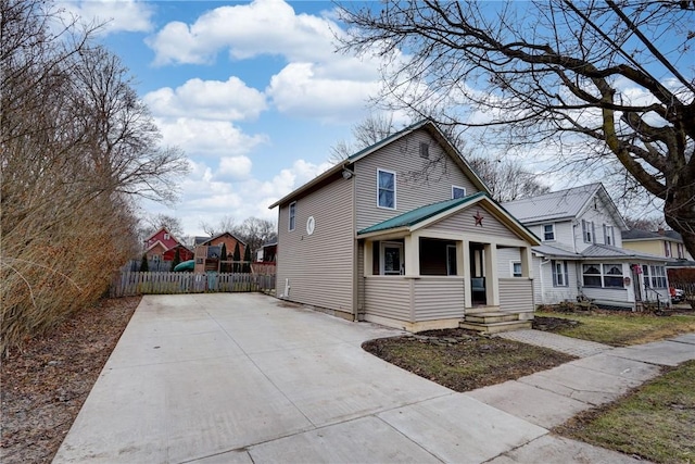 traditional home featuring covered porch and fence