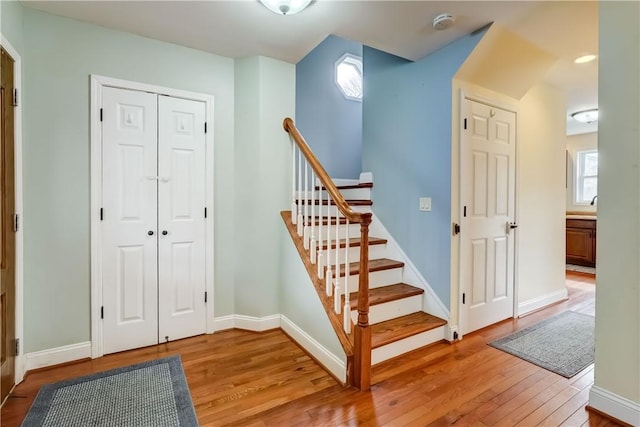 staircase with baseboards and wood finished floors