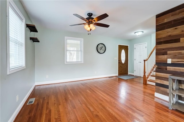 entryway featuring visible vents, plenty of natural light, stairs, and wood finished floors