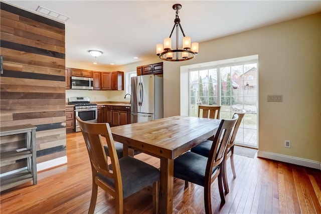 dining area with light wood-type flooring, visible vents, recessed lighting, an inviting chandelier, and baseboards