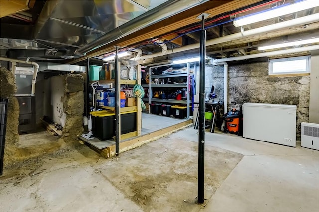 basement featuring heating unit and refrigerator