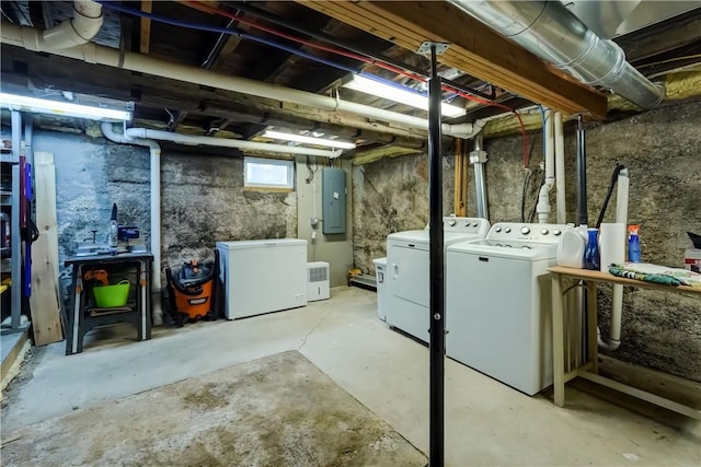 basement featuring refrigerator, electric panel, and washing machine and dryer