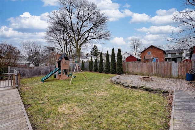 view of yard with an outdoor fire pit, a playground, and a fenced backyard