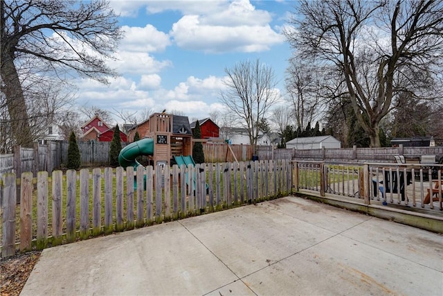 view of patio with fence and a playground