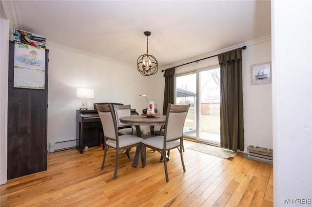 dining room with light wood finished floors, baseboard heating, crown molding, and a chandelier