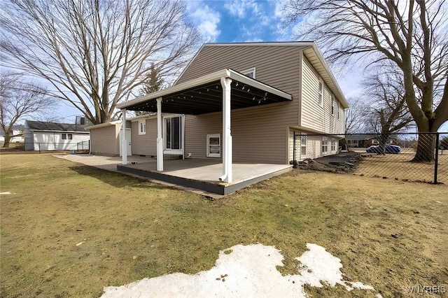 rear view of house with a patio, a yard, and fence