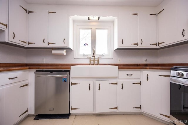 kitchen featuring butcher block countertops, decorative backsplash, white cabinets, stainless steel appliances, and a sink