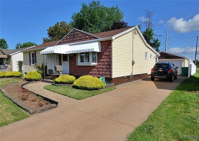 view of front of home featuring an outbuilding, concrete driveway, a front yard, and crawl space