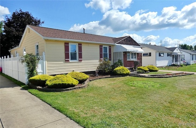 view of front facade with a front yard and fence