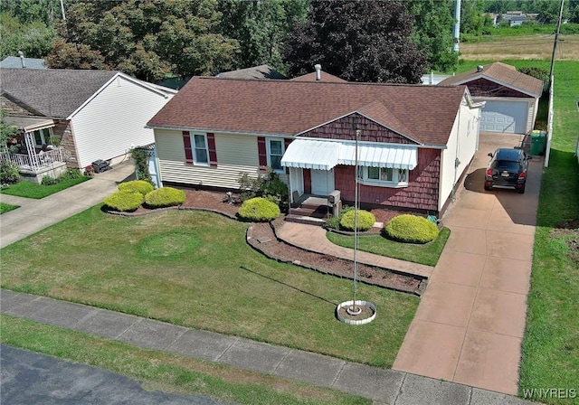 view of front of home featuring concrete driveway, a front yard, and roof with shingles