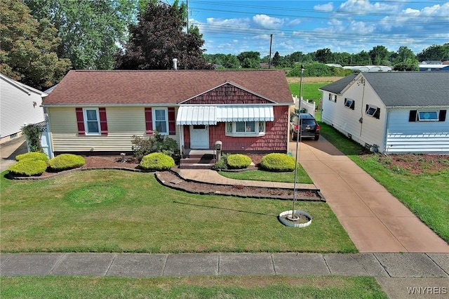 view of front of home with a front lawn, driveway, and roof with shingles