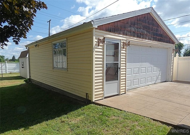 view of home's exterior with a yard, fence, and a garage