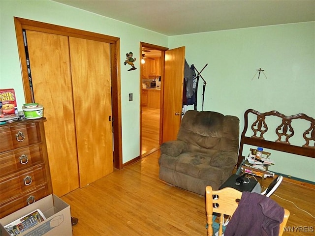 living area featuring baseboards and light wood-style flooring