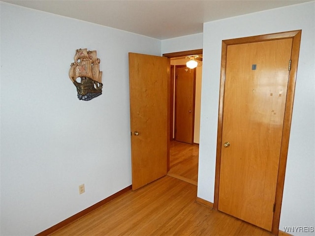 empty room with light wood-type flooring and baseboards