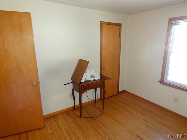 unfurnished room with light wood-style flooring and baseboards