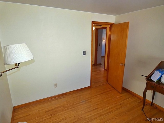 spare room with light wood-type flooring and baseboards