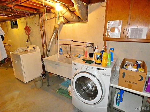 clothes washing area with laundry area, independent washer and dryer, and a sink