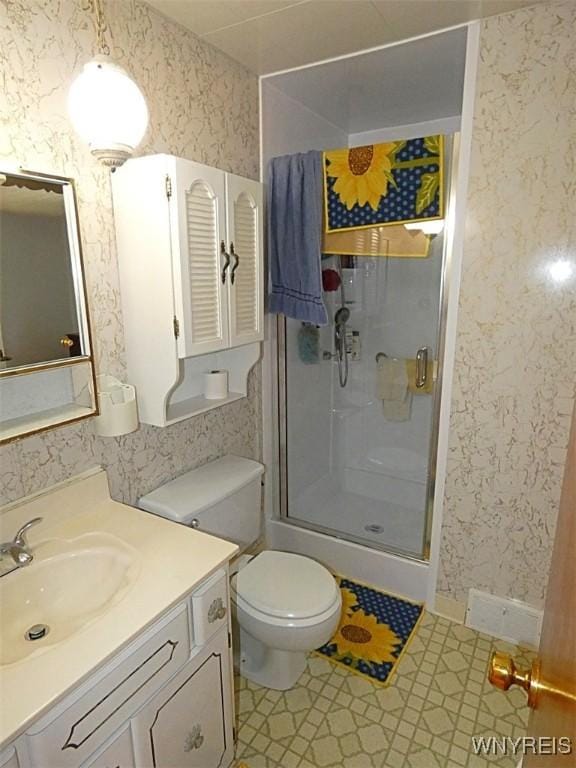 full bathroom with vanity, toilet, a shower stall, and wallpapered walls