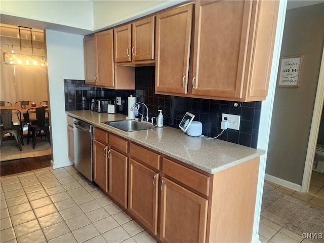 kitchen featuring a sink, backsplash, light tile patterned floors, baseboards, and dishwasher