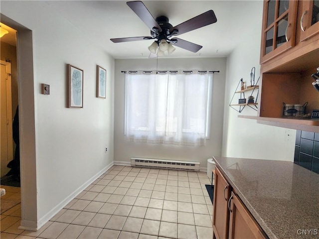 interior space featuring glass insert cabinets, baseboards, light tile patterned floors, brown cabinets, and a baseboard radiator