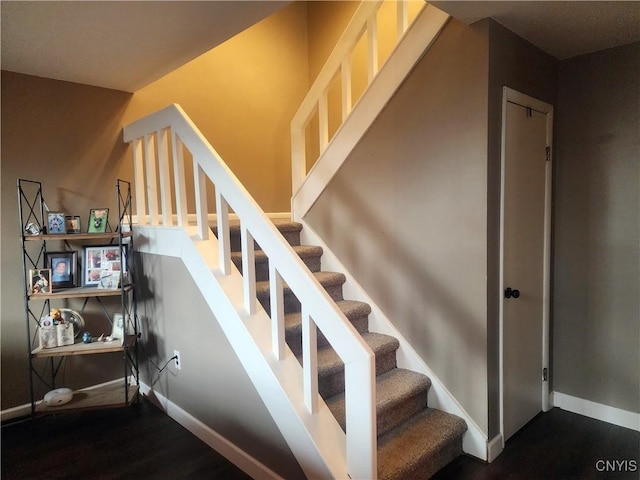 staircase with baseboards and wood finished floors