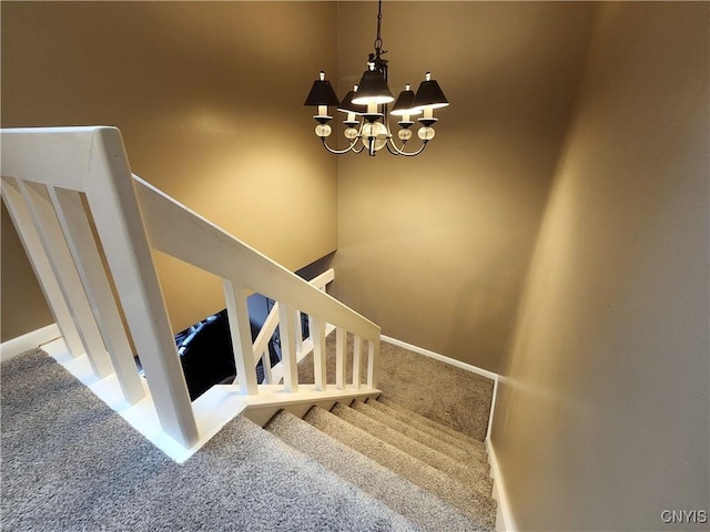 stairway featuring an inviting chandelier, carpet flooring, and baseboards