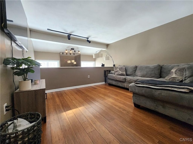 living room with track lighting, baseboards, and hardwood / wood-style floors