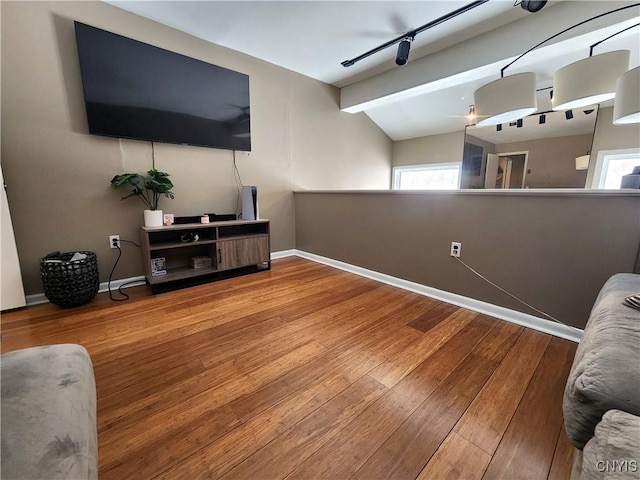 living room with track lighting, vaulted ceiling with beams, baseboards, and wood-type flooring