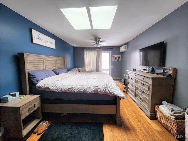 bedroom featuring baseboard heating, a skylight, light wood-style floors, and a ceiling fan