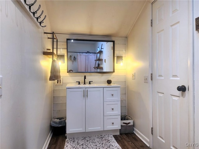 bathroom with vanity, wood finished floors, and baseboards