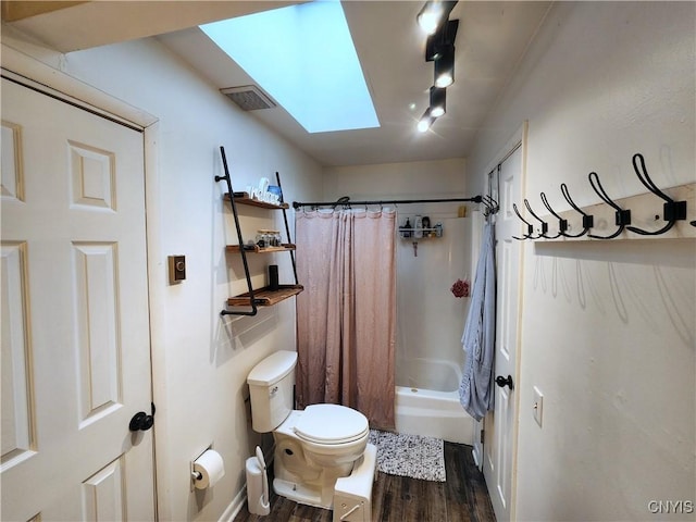 bathroom with visible vents, toilet, shower / bath combo with shower curtain, a skylight, and wood finished floors