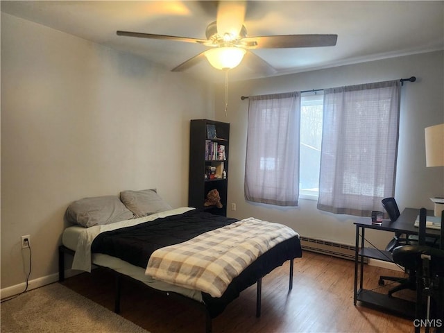 bedroom with baseboards, baseboard heating, wood finished floors, and a ceiling fan