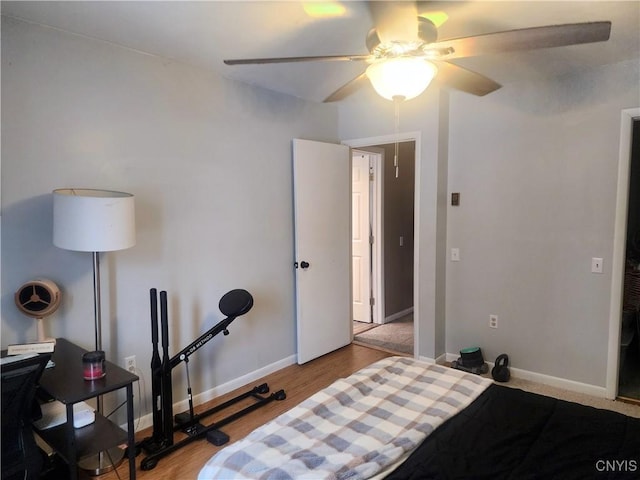 bedroom featuring ceiling fan, baseboards, and wood finished floors