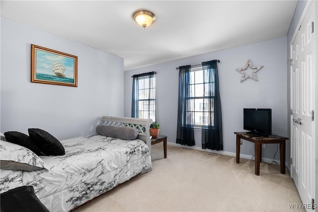 bedroom featuring light carpet, baseboards, and a closet