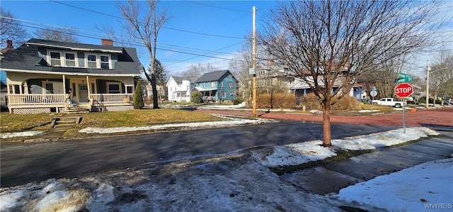 view of road with traffic signs, a residential view, and sidewalks