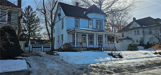 victorian house with a garage, covered porch, and an outdoor structure