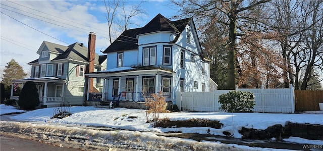 victorian-style house with covered porch and fence