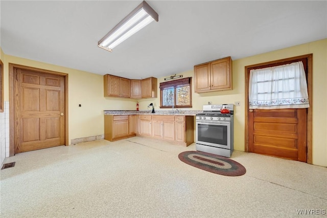 kitchen featuring stainless steel stove, light countertops, and visible vents