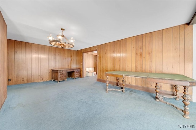 miscellaneous room with a chandelier, carpet flooring, and wood walls