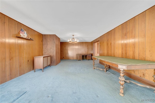 playroom featuring wooden walls, a notable chandelier, and carpet