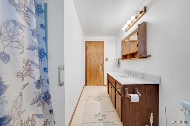 bathroom featuring a shower with shower curtain, baseboards, vanity, and tile patterned floors