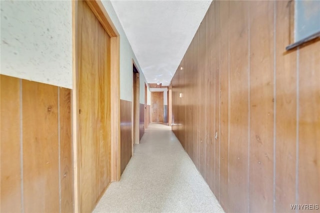 corridor featuring wooden walls