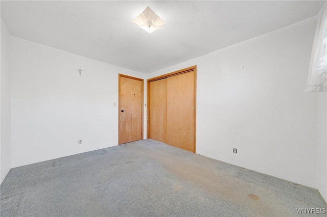 unfurnished bedroom featuring a closet and carpet floors