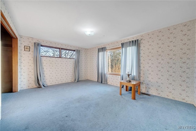 carpeted spare room with wallpapered walls