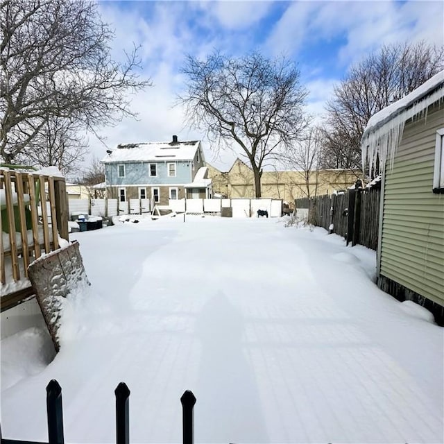 yard layered in snow featuring fence