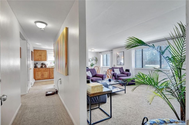 hall featuring light colored carpet and baseboards