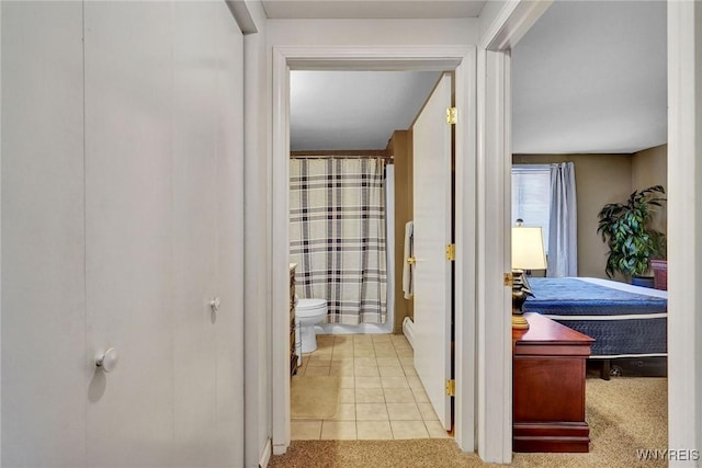 hall with tile patterned floors and carpet flooring