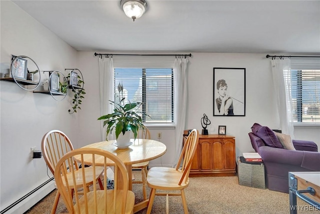 dining space featuring a baseboard heating unit and light colored carpet